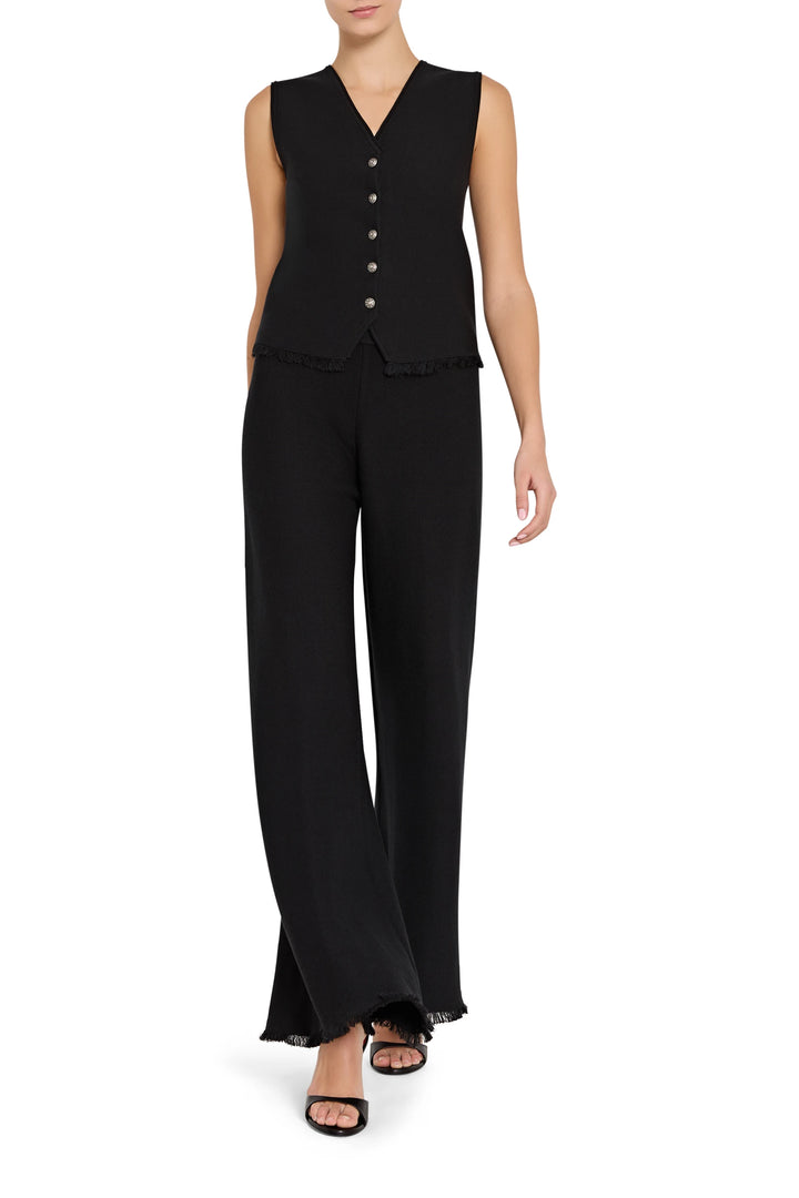 Woman wearing a black sleeveless top and wide-leg pants on a white background