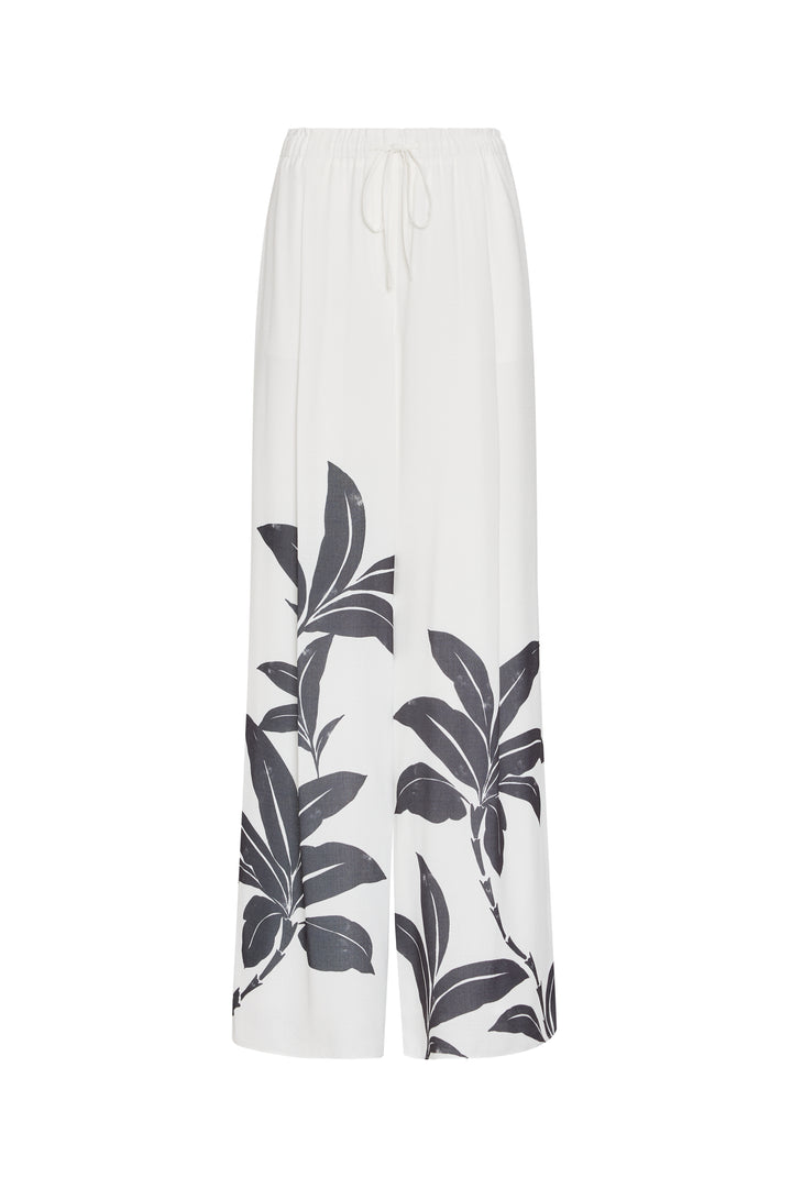 White pants with black leaf pattern on a white background