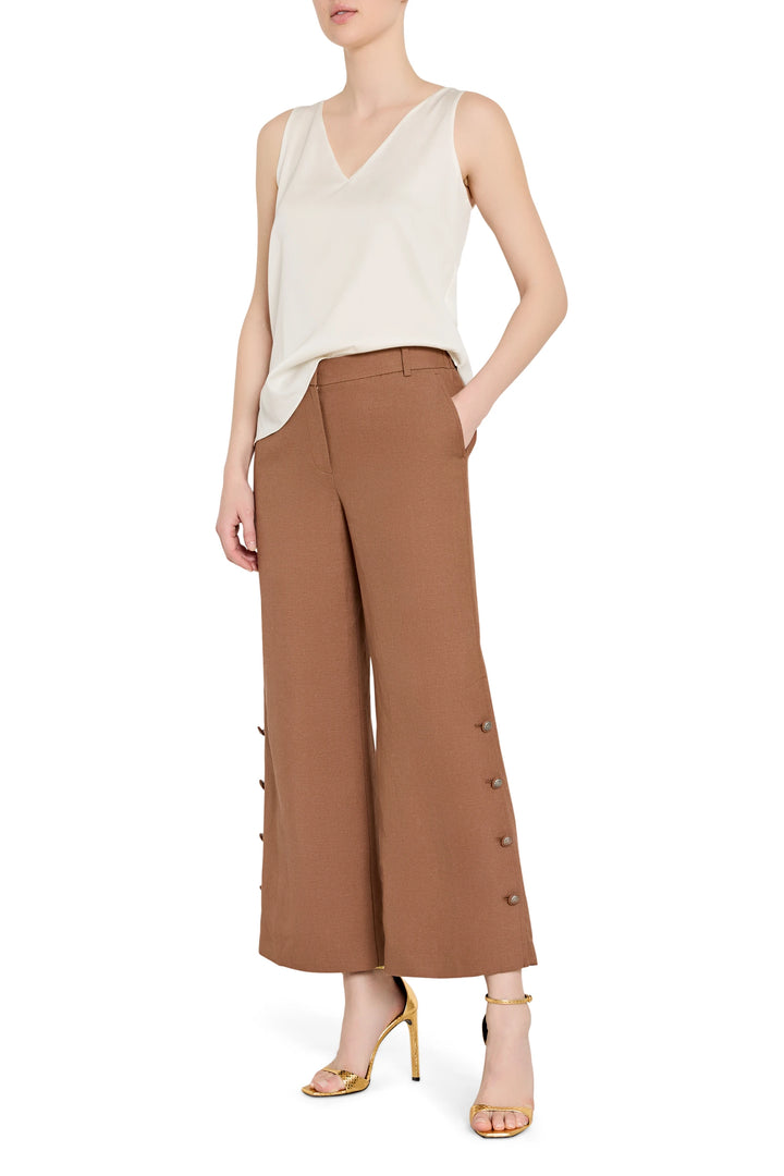 Wide-leg linen pants with artisan button detailing at front waist, structured silhouette; front view on model.