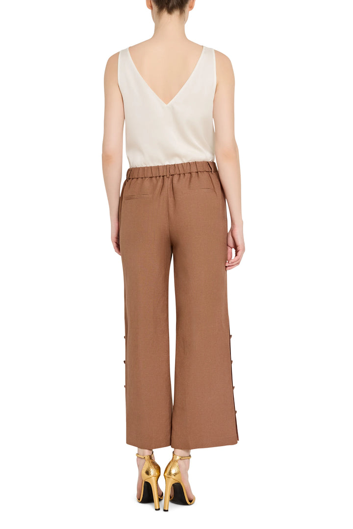 Wide-leg linen pant with clean waistband, subtle pleating, and flowing drape; back view on model.