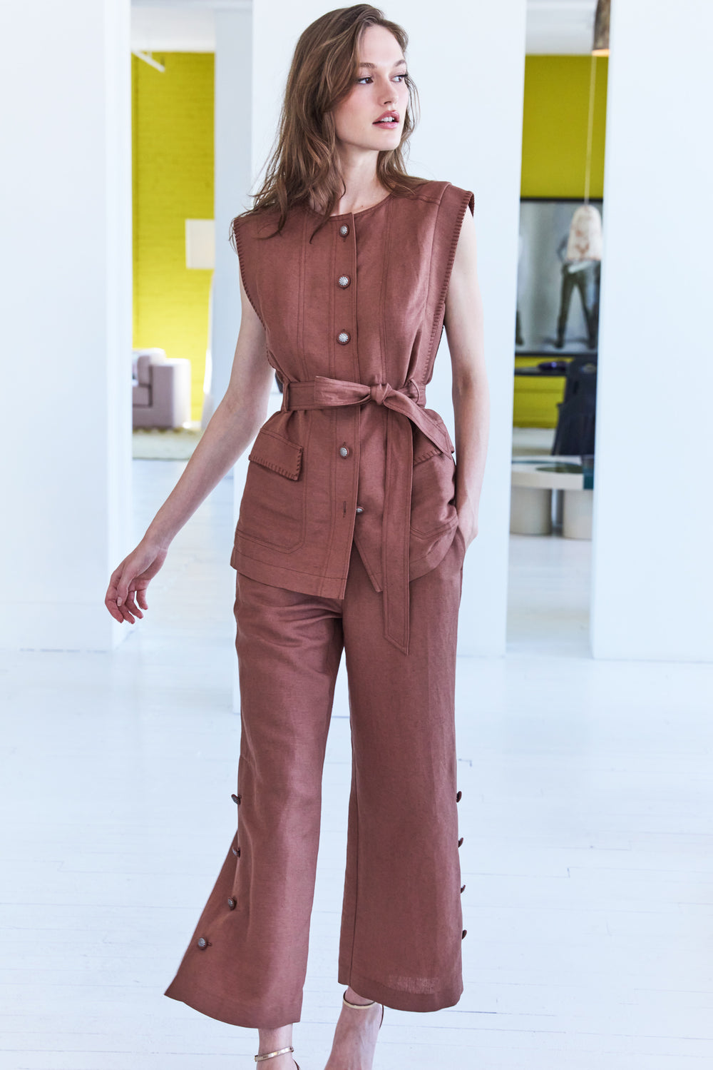 Sleeveless linen vest with belted waist, notched collar, and straight silhouette. Front view on white.