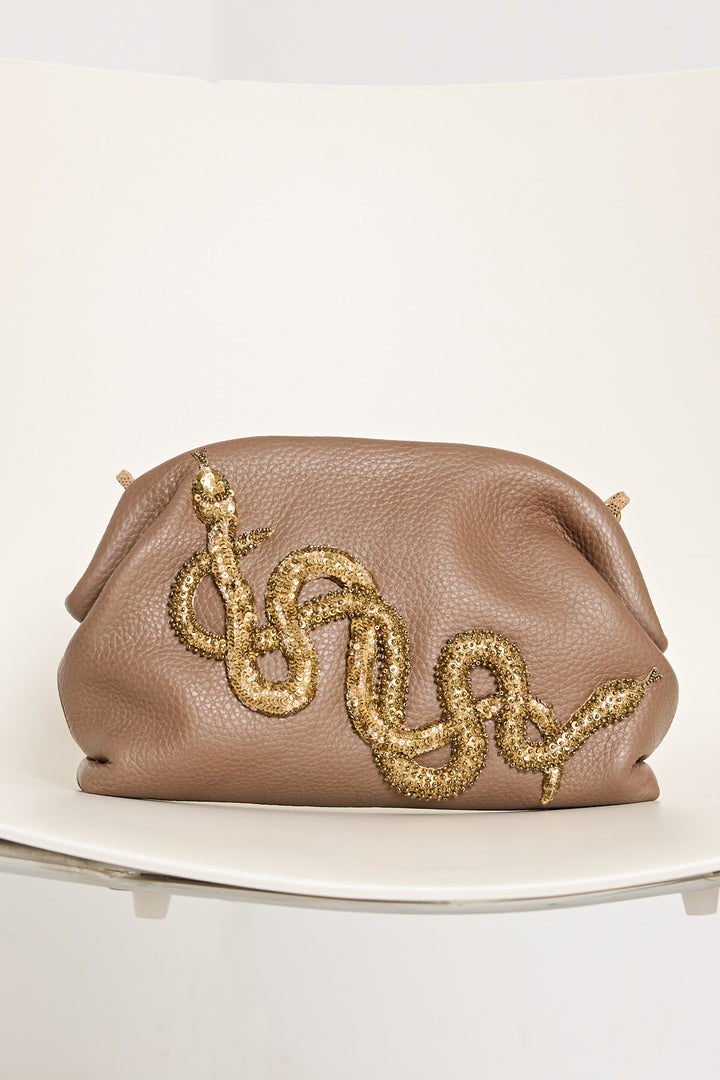 Brown clutch bag with gold snake design on a white surface